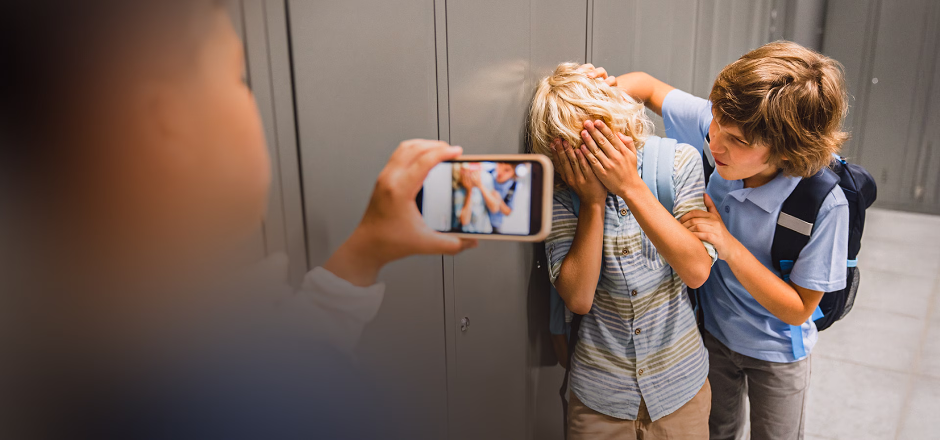 Adolescente sendo filmado por colegas no corredor da escola